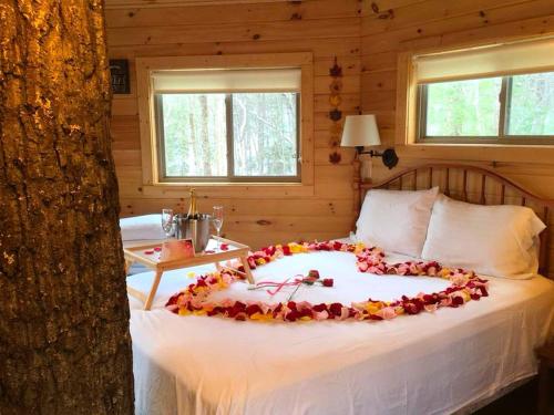 a bed with a heart made out of flowers on it at Stunning Tree House Rental in the Forest near Beckley, West Virginia in Hico