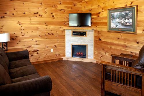 a living room with a fireplace and a tv at Fantastic Cozy Cabin with Fire Pit, Hot-tub and Fireplace in Herod, Illinois in Karbers Ridge
