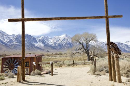 a wooden cross in the desert with mountains in the background at Stunning Design Rental Incredible for a Luxury Escape in Lone Pine, California in Lone Pine