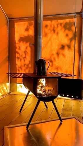 a stove with a fire in a room with a window at Luxury Safari Style Tents for Getaways in Pennsylvania in East Berlin