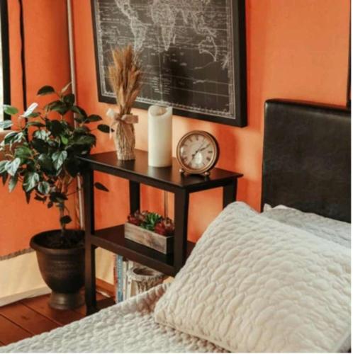 a bedroom with a bed and a table with a clock at Luxury Safari Style Tents for Getaways in Pennsylvania in East Berlin