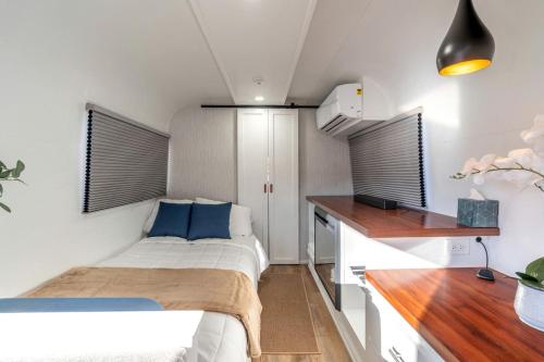a small bedroom with a bed and a desk at Unique Airstream Stay in Downtown Prescott AZ Near Whiskey Row in Prescott
