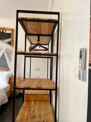 a room with a wooden shelf next to a bed at Eagle View Lodge - Kigali in Kigali
