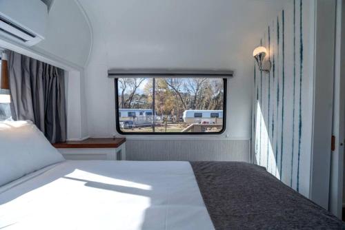 a bedroom with a bed and a window at Downtown Prescott AZ Airstream Stay Near Whiskey Row with Outdoor Amenities in Prescott