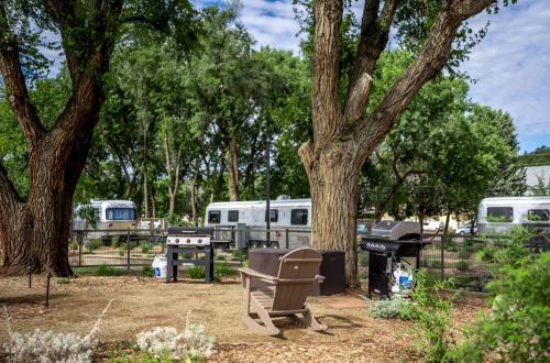 a park with a bench and a grill and trees at Downtown Prescott AZ Airstream Stay Near Whiskey Row with Outdoor Amenities in Prescott