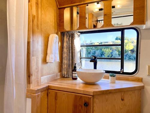 a bathroom with a bowl sink and a window at Luxe Pet-Friendly Airstream Retreat: Glamping Paradise in Grand Junction, Colorado in Grand Junction