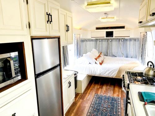 a small kitchen with a bed and a refrigerator at Riverside Airsteram Adventure in Colorado - Relaxation by the Water in Grand Junction in Grand Junction