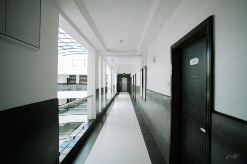a hallway of a building with a black door at Daksh The Madhuvan Suites Dwarka in Dwarka