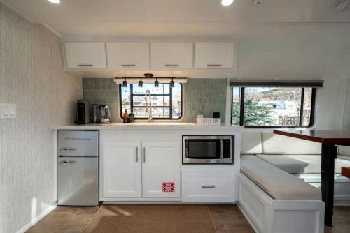 a small kitchen with white cabinets and a microwave at Airstream Stay Near Whiskey Row and Granite Creek in Prescott, AZ in Prescott