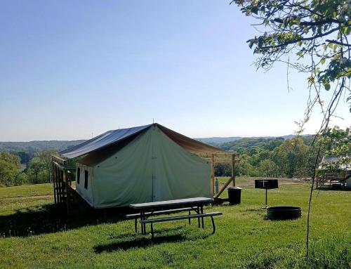 a large tent in a field with a picnic table at Cozy Tented Cabin with Fire Pit and Barbecue in Logan, Ohio in Logan