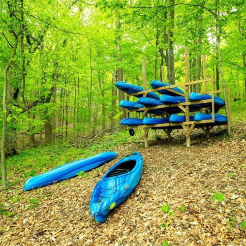 a group of kayaks sitting on the ground in the woods at Cozy Tented Cabin with Fire Pit and Barbecue in Logan, Ohio in Logan