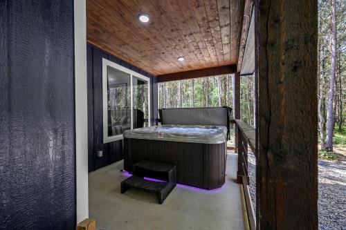 a room with a bed on the outside of a house at Breathtaking Luxurious Cabin with Fire Pit, Screened Beautiful Porch and Jacuzzi in Oklahoma in Mount Herman