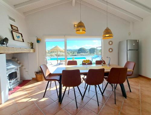 a kitchen and dining room with a table and chairs at Monte Sossego by Estilo Lusitano, com piscina privada in Grândola