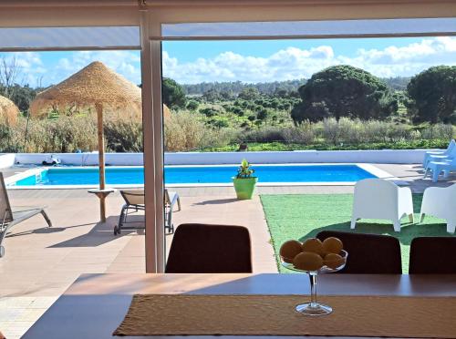 a dining room with a view of a pool at Monte Sossego by Estilo Lusitano, com piscina privada in Grândola