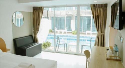 une chambre avec un lit et une vue sur une piscine dans l'établissement Pool Villa @Donmueang, à Bangkok