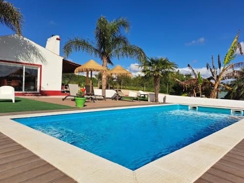 a swimming pool in front of a house at Monte Sossego by Estilo Lusitano, com piscina privada in Grândola