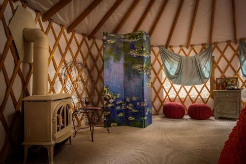 a room with a yurt with a stove in it at Elegant Yurt Tucked Beneath Oak Trees on Southern California Ranch in Cayucos