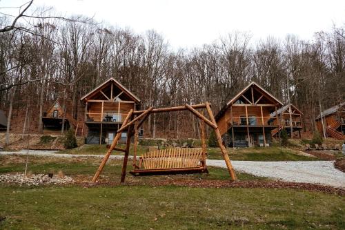 un parco con un'altalena di legno davanti a una casa di Rustic Tree A-Frame with Original Design by Tappan Lake in Ohio 