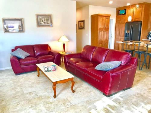 ein Wohnzimmer mit zwei roten Ledersofas und einem Tisch in der Unterkunft Large Family Retreat in Page, Arizona, Perfect for a Weekend Getaway for Large Groups in Page