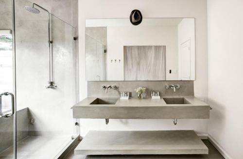 ein Badezimmer mit Waschbecken und Spiegel in der Unterkunft Modern Luxury Rental with Bohemian Decor near Antique Show in Round Top, Texas in Round Top