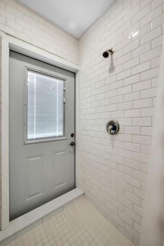 a shower stall with a door and a window at Upcycled Shipping Containers Transformed into a Glamping Home for a Unique Florida Vacation in Tequesta
