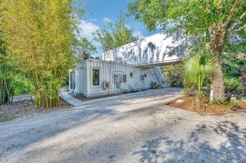 an empty road in front of a white house at Upcycled Shipping Containers Transformed into a Glamping Home for a Unique Florida Vacation in Tequesta