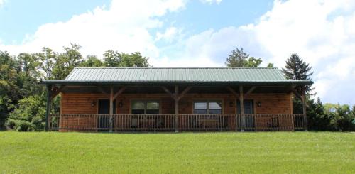 a log cabin with a deck in a field at Vacation Rental for Things to Do in Rocky Gap State Park in Flintstone