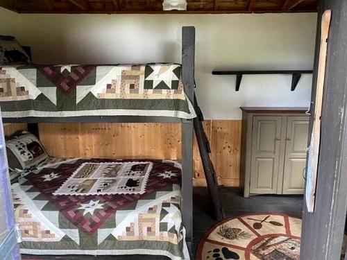une chambre avec deux lits superposés dans une pièce dans l'établissement Charming Lakeside Cabin Bungalow with Timeless Rustic Beauty near Portage Lake in Maine, à Portage Lake Municipal Seaplane Base