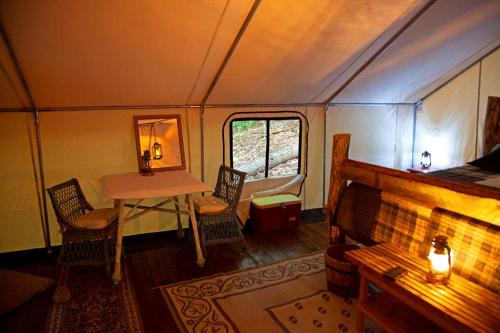 a room with a table and chairs in a train car at Rustic Safari Tent for a Unique Glamping Experience near Gore Mountain, New York in North Creek
