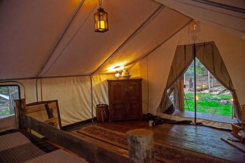 a tent with a wooden floor and a large window at Rustic Safari Tent for a Unique Glamping Experience near Gore Mountain, New York in North Creek