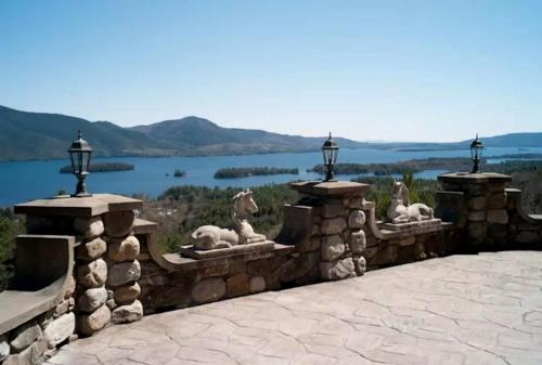 a stone retaining wall with a view of a lake at Regal Suite Rental in Breathtaking Castle near Lake George, Upstate New York in Bolton Landing