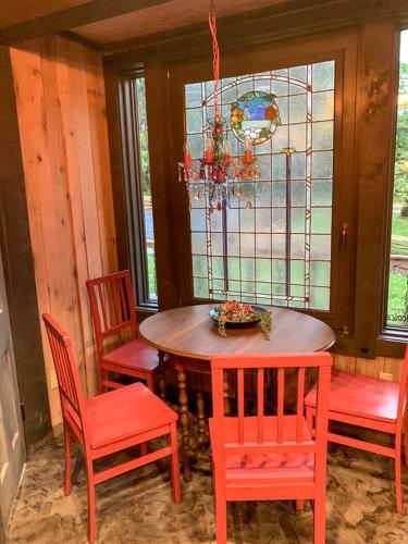 a dining room with a table and chairs and a stained glass window at Unique Hobbit House Accommodation with a Private Hot Tub in Shenandoah, Virginia in Grove Hill