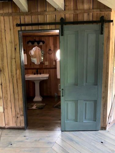 an open door to a bathroom with a sink at Unique Hobbit House Accommodation with a Private Hot Tub in Shenandoah, Virginia in Grove Hill