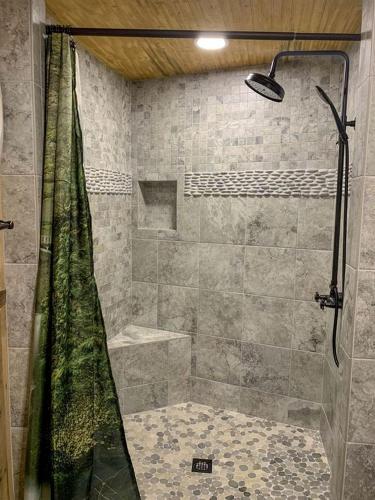 a shower with a shower curtain in a bathroom at Unique Hobbit House Accommodation with a Private Hot Tub in Shenandoah, Virginia in Grove Hill