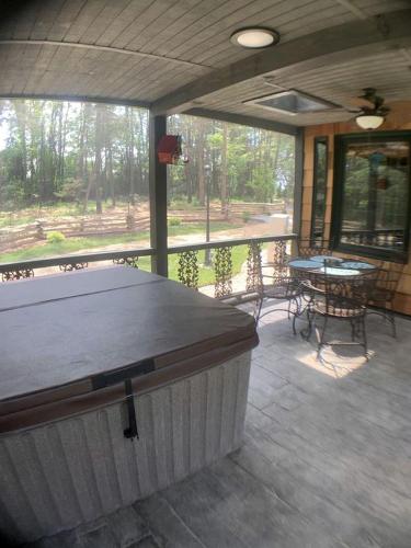 a screened in porch with a table and chairs at Unique Hobbit House Accommodation with a Private Hot Tub in Shenandoah, Virginia in Grove Hill