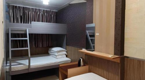 a bedroom with a bunk bed with towels on it at New Mong Kok Guest House in Hong Kong