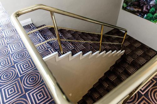 a staircase with a metal hand rail and a stair case at The Belmore Apartments Hotel in Wollongong