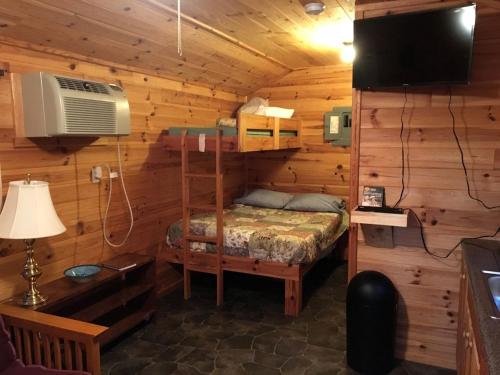Un dormitorio con una litera en una cabaña de madera en Log Cabin for Family Glamping Vacation near Cherry Springs State Park, Pennsylvania, en Short Run