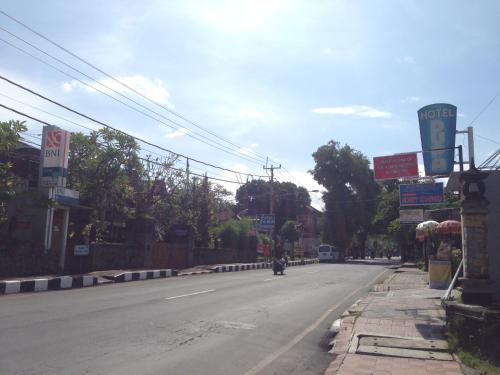 an empty street with a motorcycle driving down the road at Hotel Dupa in Lovina