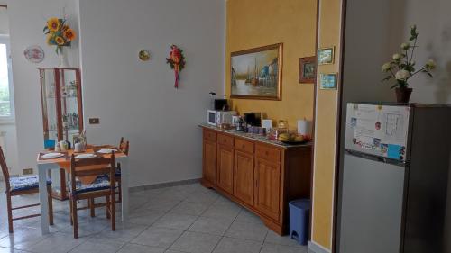 a kitchen with a table and a refrigerator at B&B I Tre Ulivi in Morro dʼOro