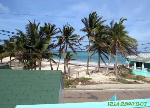 a view of a beach with palm trees and a house at Villa Sunny Days in San Andrés