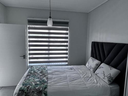 Un dormitorio con una cama frente a una ventana. en The Blyde Inn, en Pretoria