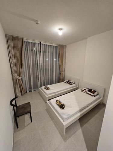 a room with two beds and a chair in it at Luxury 2-Bedroom APT - Sea Views in Saadiyat Island in Abu Dhabi