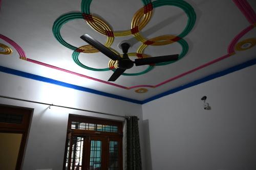 a ceiling with a painting of a fan on a room at maa kalishila home stay in Ukhimath