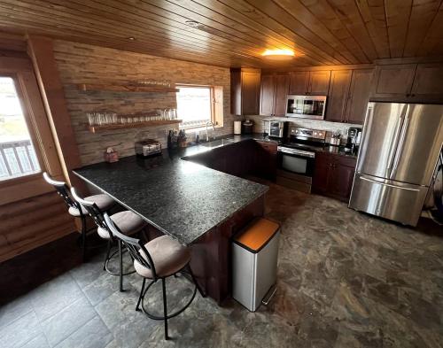 a kitchen with a large island in the middle at Scenic Vacation Home with Wrap-Around Deck Overlooking Ennis Lake near McAllister, Montana in Ennis