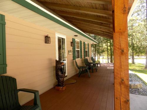 a covered porch of a house with chairs on it at Spacious Vacation Rental with a Stunning Stone Gas Fireplace in Fish Creek, Wisconsin in Fish Creek