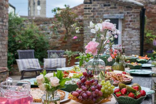 a table with plates of food and flowers in vases at The Haven in Sandwich