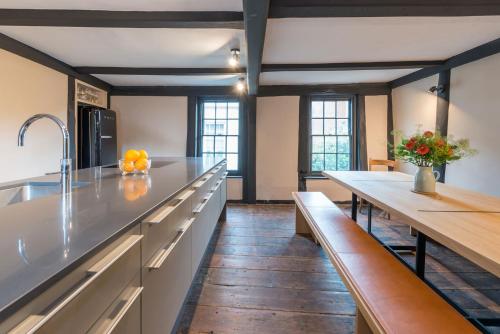 a large kitchen with wooden floors and white counter tops at The Haven in Sandwich