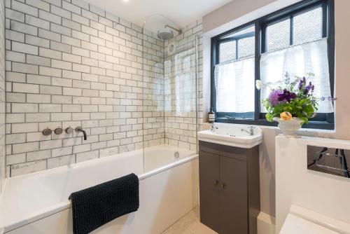 a bathroom with a bath tub and a sink and a bath tubermott at The Haven in Sandwich