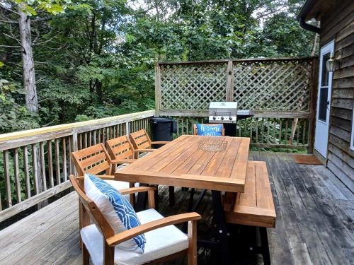 a wooden table and chairs on a deck at Resplendent Cabin Haven near Shenandoah River in Virginia in Bentonville